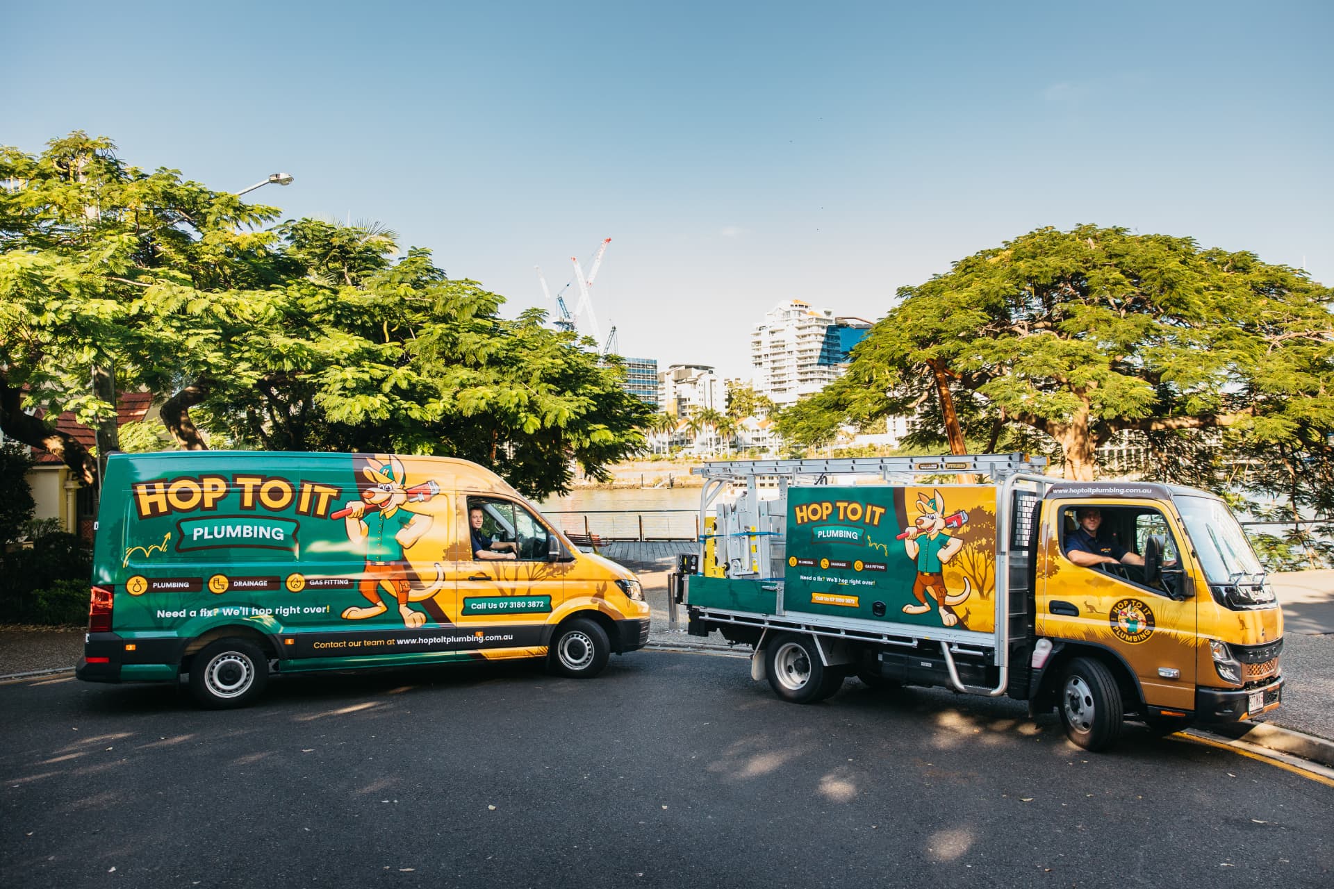 Hop To It van and tipper truck parked by the Brisbane River